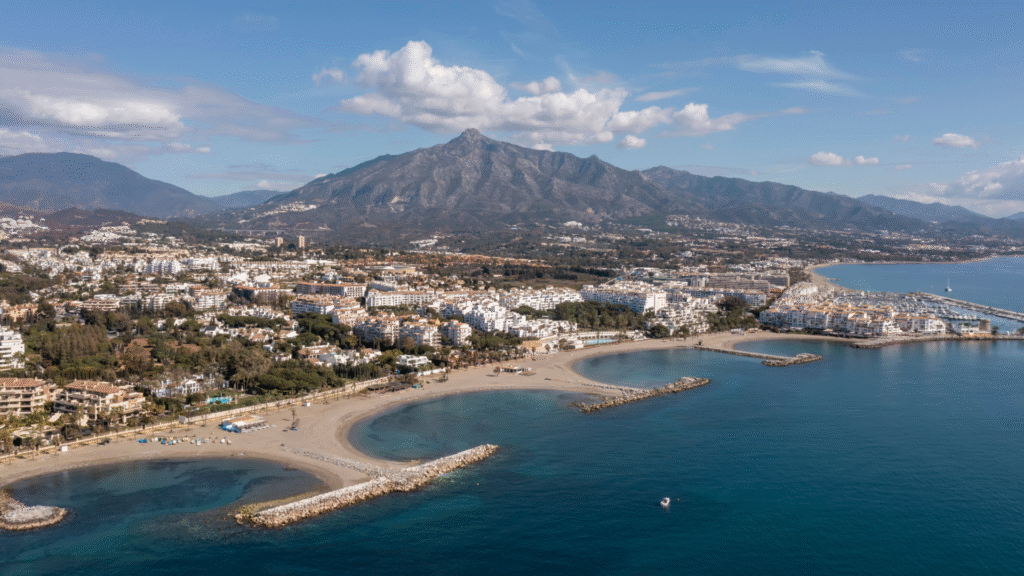 Aerial view of Marbella and Nueva Andalucía, Costa del Sol — beachfront, marina, and La Concha mountain backdrop showcasing Mediterranean coastal -Quintessentia Propety Advisors