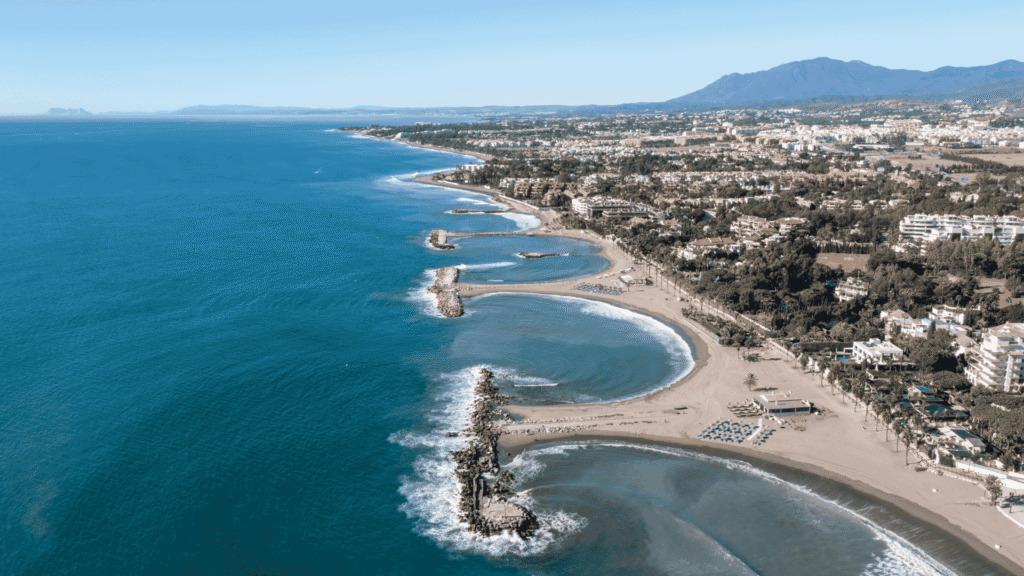 Aerial view of coastal homes and beaches near Marbella, showcasing some of the best areas to live in Nueva Andalucia.