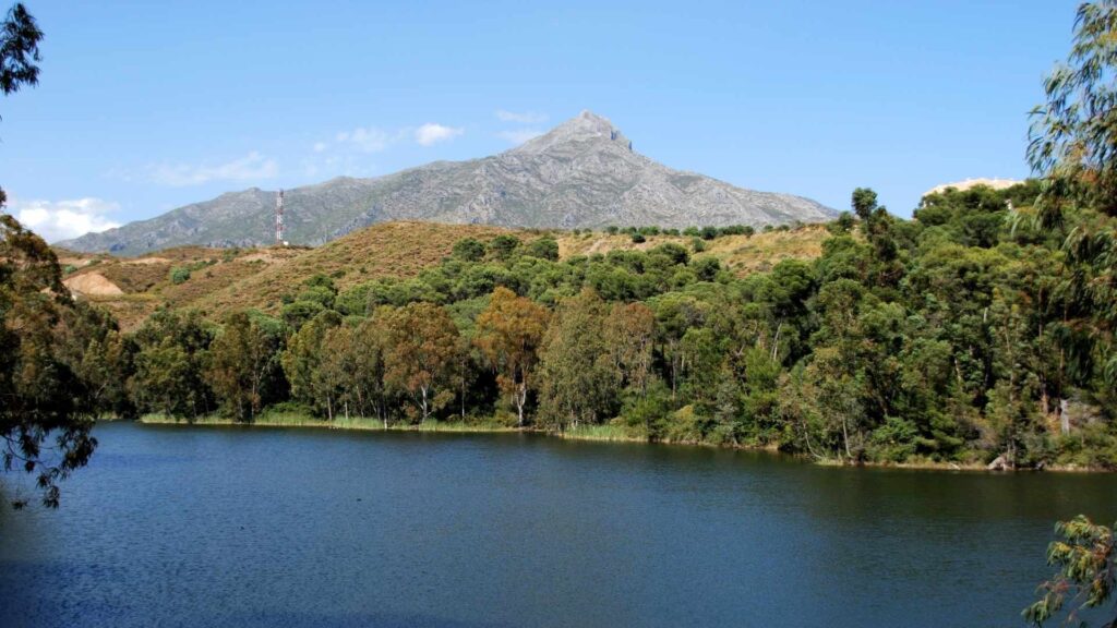Scenic view of La Concha Mountain and lake in Nueva Andalucia, Spain, showcasing the clear blue skies typical of the Nueva Andalucian climate
