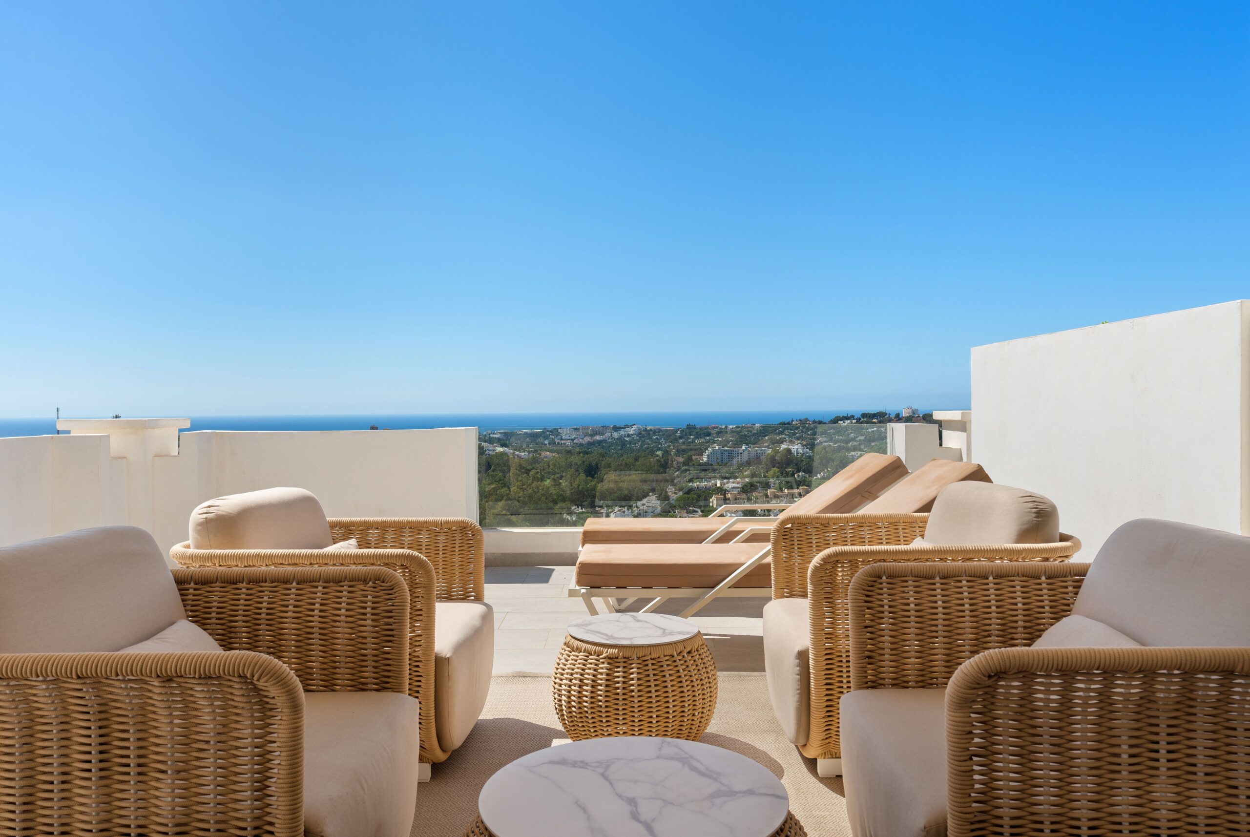 Modern terrace with sea views and outdoor seating in luxury apartment in Marbella