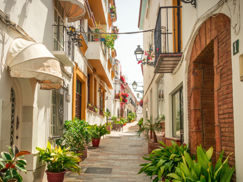 Charming old town street in Marbella with whitewashed homes and flowers.