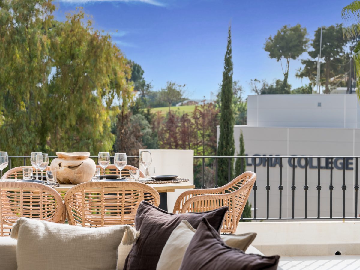Terrace dining area at Los Pinos de Aloha overlooking Aloha College and lush greenery in Marbella