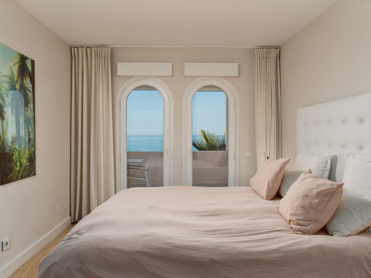 Bright bedroom with soft pink bedding and modern en-suite design in Playa del Moral apartment