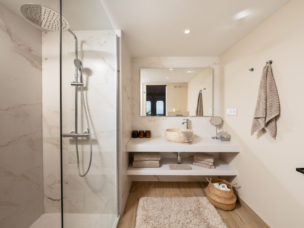 Elegant bathroom with walk-in marble shower and modern vanity in Playa del Moral apartment