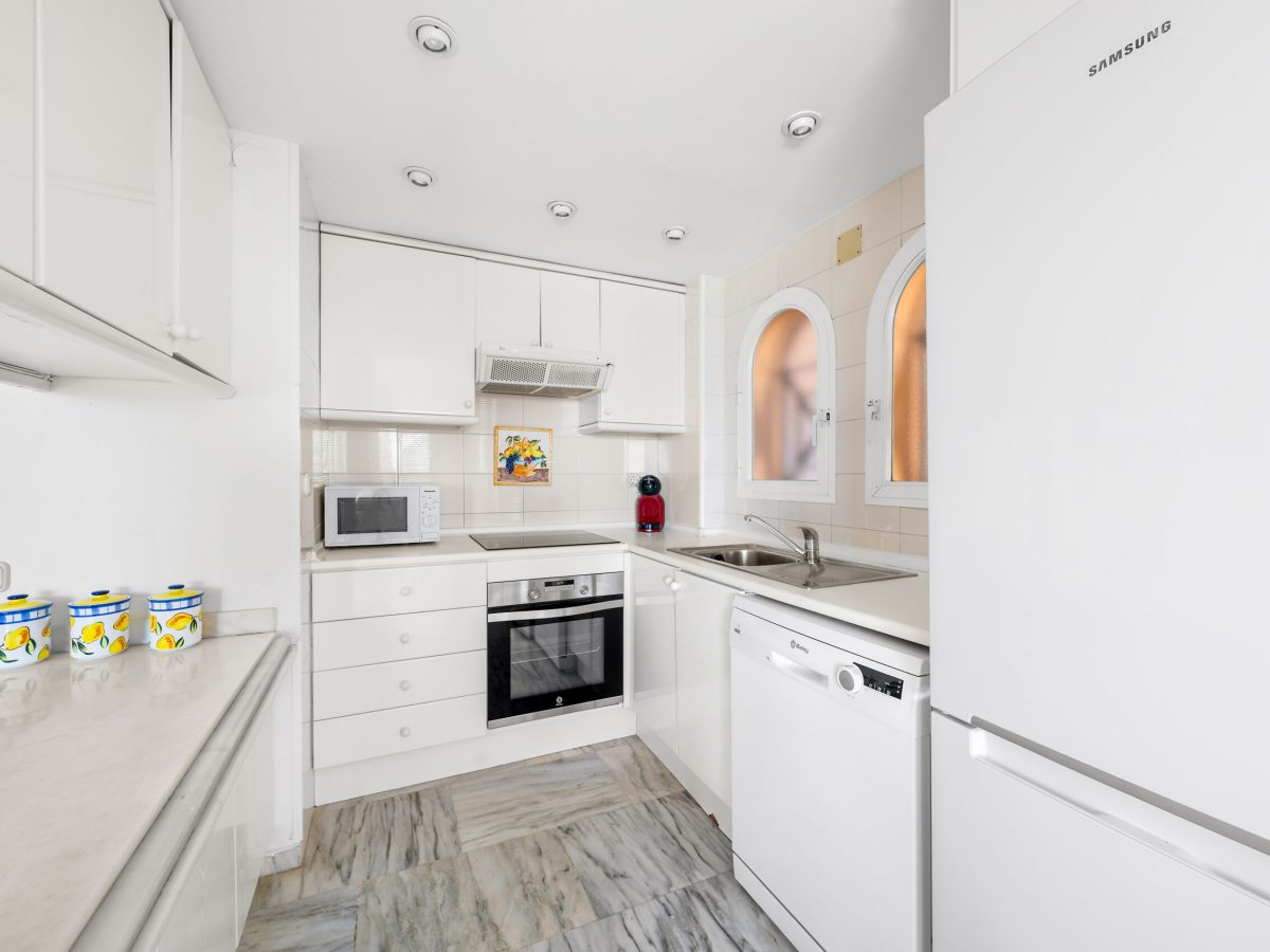 Fully fitted white kitchen in beachfront apartment Estepona