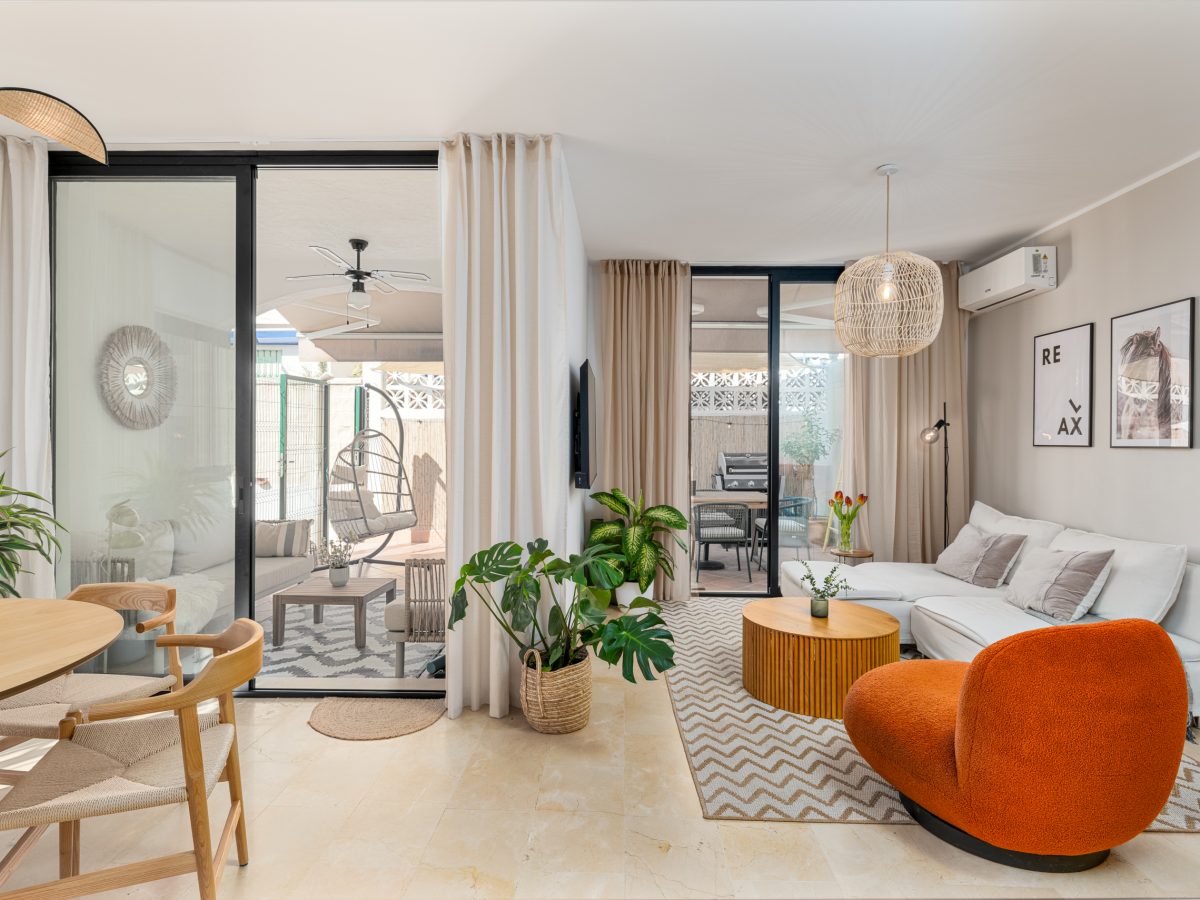 Modern living room in Bel-Air semi-detached home near Marbella, featuring neutral tones, indoor plants, and open access to a stylish terrace