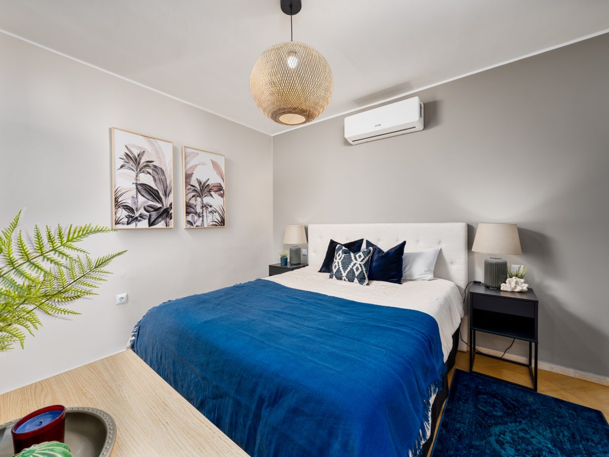 Stylish bedroom in Bel-Air semi-detached home near Marbella, featuring modern decor with neutral walls, blue accents, wall art, and contemporary lighting