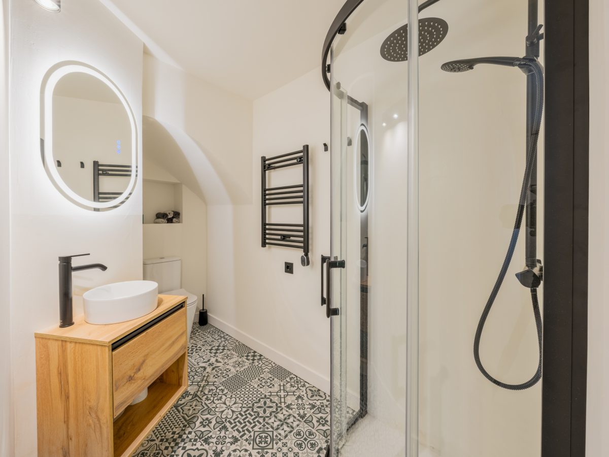Modern bathroom with walk-in shower and wooden vanity in Estepona Old Town apartment