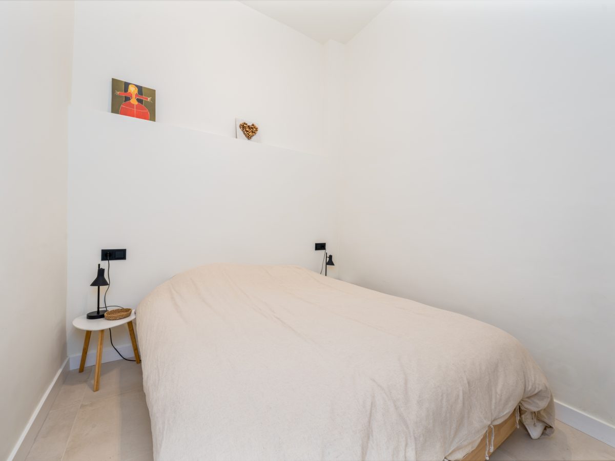 Cozy minimalist bedroom with neutral tones and simple decor in Estepona old town apartment.