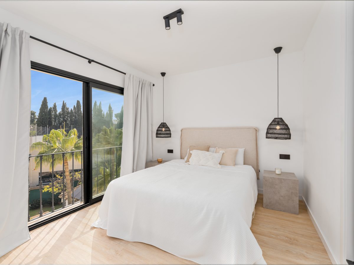 Bright bedroom with large windows and modern decor at Los Pinos de Aloha, Marbella.