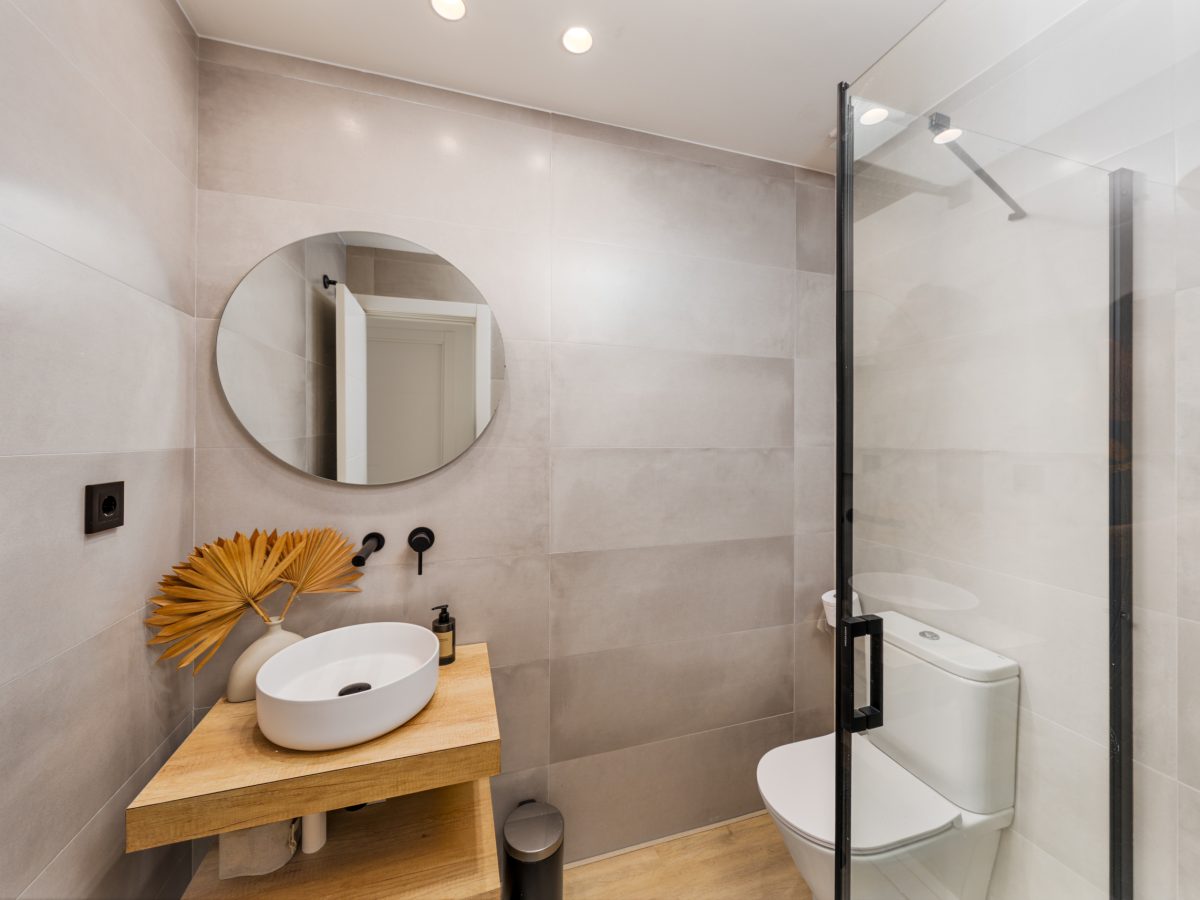 Modern guest bathroom with walk-in shower and round mirror at Los Pinos de Aloha, Marbella