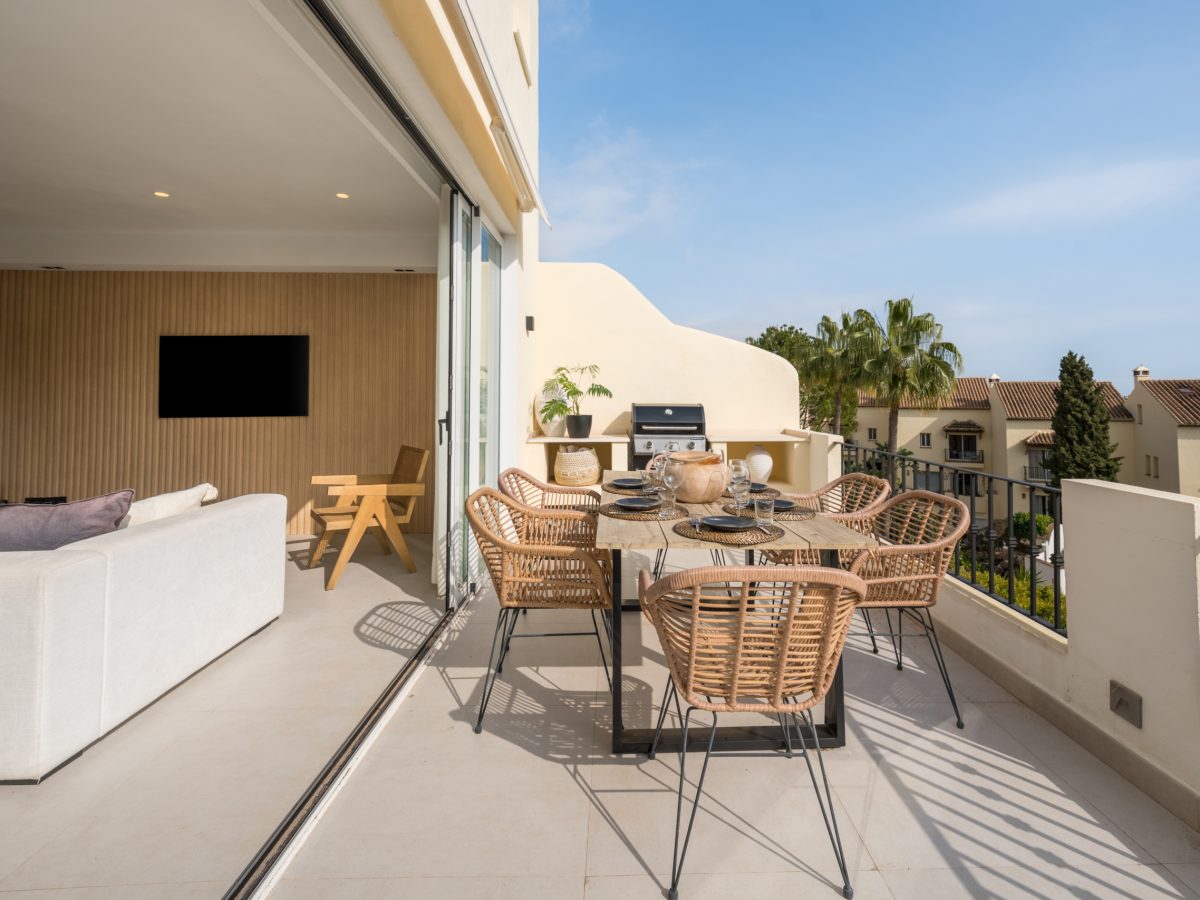 Modern terrace with outdoor dining area and open-plan living room in Los Pinos de Aloha, Marbella