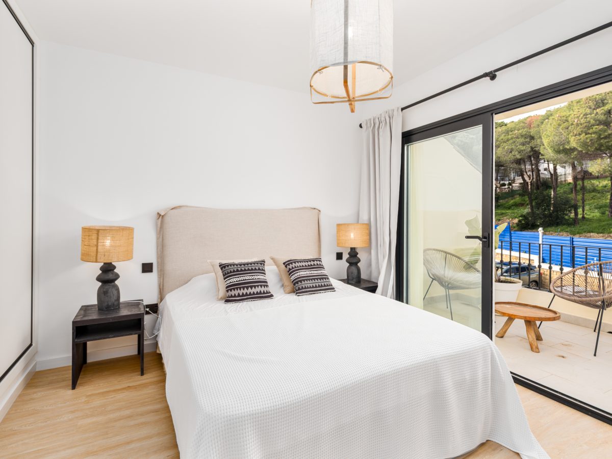 Bright bedroom with large windows and modern decor at Los Pinos de Aloha, Marbella.