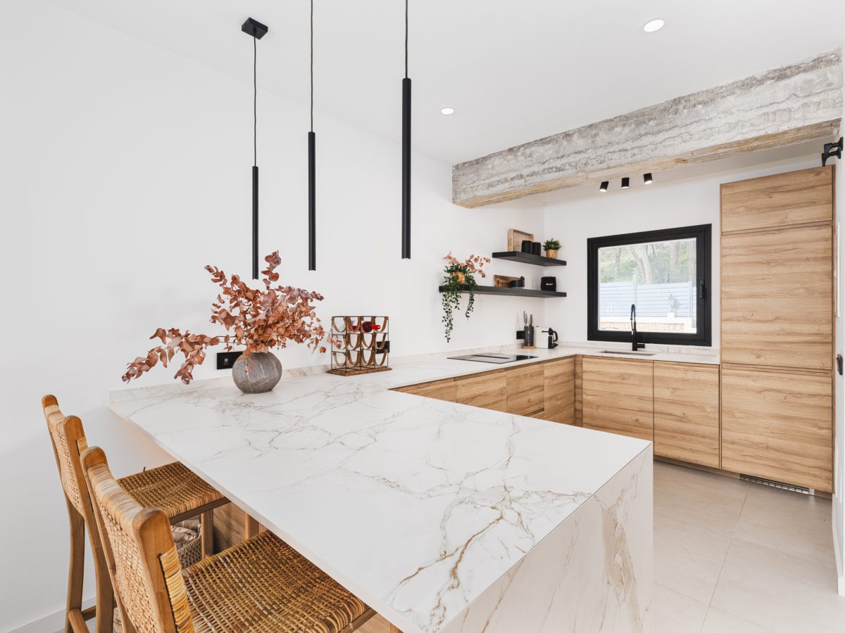 Modern kitchen interior with marble island, wooden cabinets, and minimalist lighting in Los Pinos, Marbella