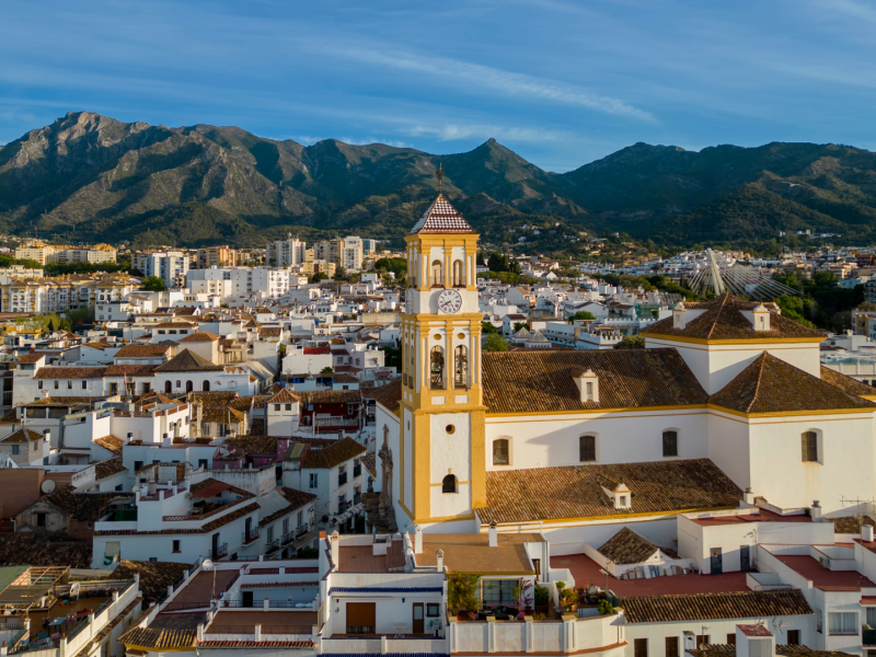 Aerial view of Marbella old town with church tower and mountain backdrop, representing property and mortgage opportunities in southern Spain.
