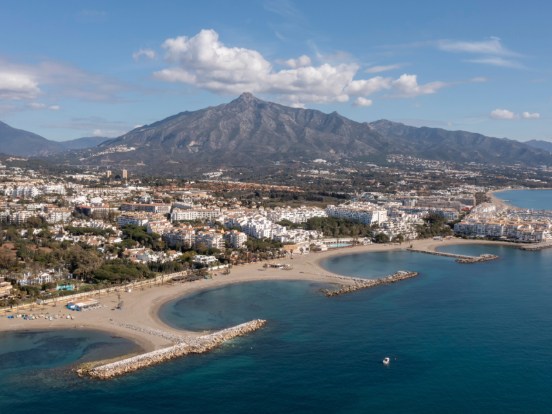 Aerial view of Marbella and Nueva Andalucía, Costa del Sol — beachfront, marina, and La Concha mountain backdrop showcasing Mediterranean coastal -Quintessentia Propety Advisors