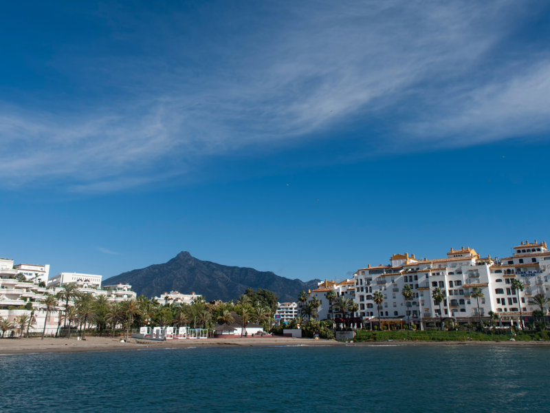 Luxury beachfront apartments along Marbella’s Golden Mile with palm trees and La Concha mountain in the background, Costa del Sol, Spain-Quintessentia Property Advisors