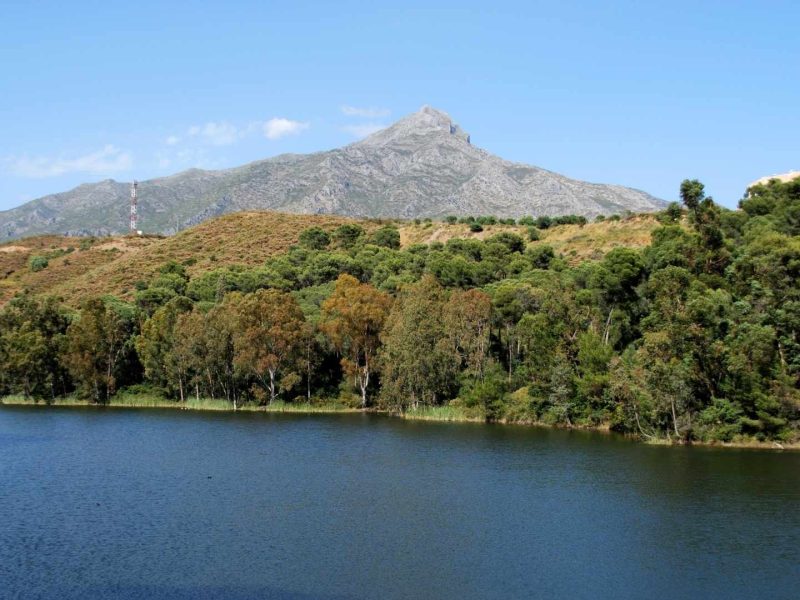 Scenic view of La Concha Mountain and lake in Nueva Andalucia, Spain, showcasing the clear blue skies typical of the Nueva Andalucian climate