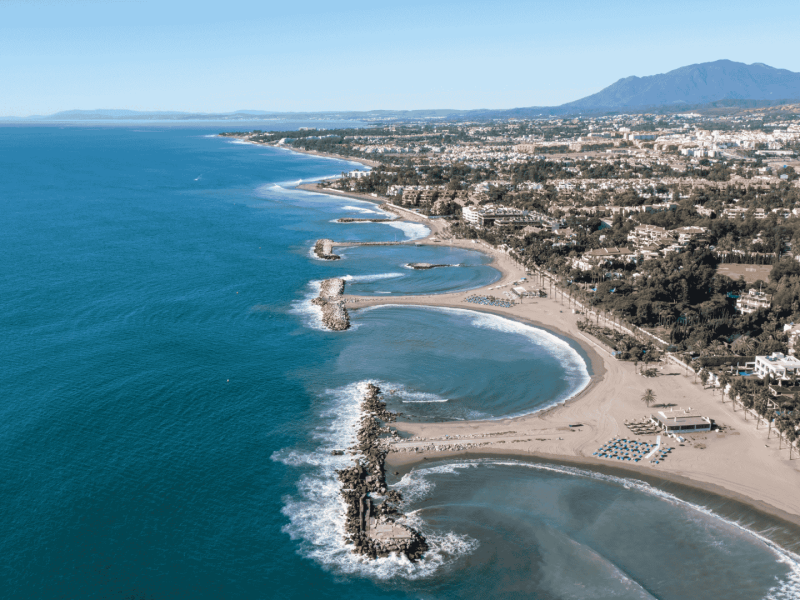 Aerial view of coastal homes and beaches near Marbella, showcasing some of the best areas to live in Nueva Andalucia.